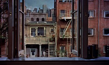 Movie still from “Rear Window” (1954), directed by Alfred Hitchcock – A view of some buildings from a window; Extreme Wide shot, High angle