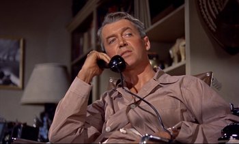 Movie still from “Rear Window” (1954), directed by Alfred Hitchcock – An older man sitting in a chair talking on a phone; Close Up shot, Low angle