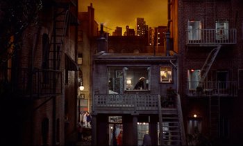 Movie still from “Rear Window” (1954), directed by Alfred Hitchcock – A view of a city at night from an alley way; Extreme Wide shot, High angle