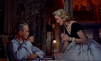 Movie still from “Rear Window” (1954), directed by Alfred Hitchcock – An older man and a young woman sitting at a table; Medium shot, Low angle