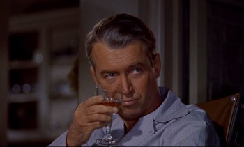 Movie still from “Rear Window” (1954), directed by Alfred Hitchcock – A person holding a wine glass; Close Up shot, Over the shoulder angle
