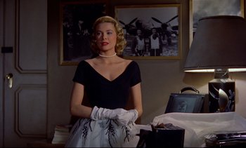 Movie still from “Rear Window” (1954), directed by Alfred Hitchcock – A beautiful blonde woman in a black dress; Medium shot, Low angle