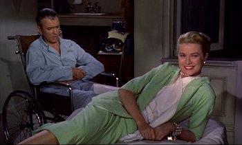 Movie still from “Rear Window” (1954), directed by Alfred Hitchcock – A man and a woman sitting in a living room; Medium shot, High angle