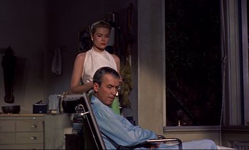 Movie still from “Rear Window” (1954), directed by Alfred Hitchcock – A man getting his hair cut by a woman in a chair; Medium shot, Over the shoulder angle