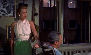 Movie still from “Rear Window” (1954), directed by Alfred Hitchcock – A woman standing next to a man in a room; Medium shot, Over the shoulder angle