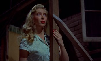 Movie still from “Rear Window” (1954), directed by Alfred Hitchcock – A woman with red lipstick looking up at the sky; Medium shot, Low angle