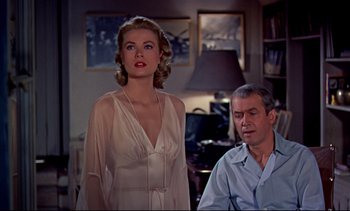 Movie still from “Rear Window” (1954), directed by Alfred Hitchcock – A man and a woman standing next to each other in a room; Medium shot, Over the shoulder angle