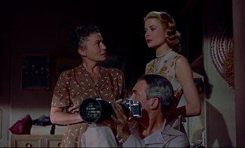 Movie still from “Rear Window” (1954), directed by Alfred Hitchcock – Two women and a man are taking a picture of each other; Medium shot, Low angle