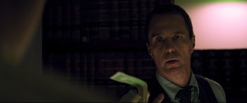 Movie still from “Richard Jewell” (2019), directed by Clint Eastwood – A man in a suit and tie looking at a piece of paper in his hand; Close Up shot, Low angle