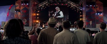 Movie still from “Richard Jewell” (2019), directed by Clint Eastwood – A crowd of people standing in front of a large screen; Wide shot, Over the shoulder angle