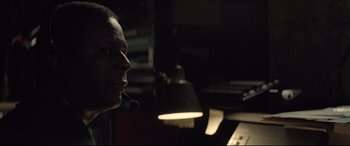 Movie still from “Richard Jewell” (2019), directed by Clint Eastwood – A man wearing a headset in a dark room; Close Up shot, Over the shoulder angle