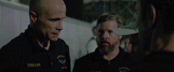 Movie still from “Richard Jewell” (2019), directed by Clint Eastwood – Two men in uniform are looking at each other with a knife in their hand; Close Up shot, Over the shoulder angle