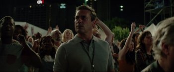 Movie still from “Richard Jewell” (2019), directed by Clint Eastwood – A man in a crowd of people standing in front of an audience; Medium shot, Over the shoulder angle