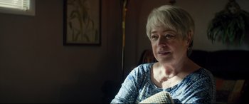 Movie still from “Richard Jewell” (2019), directed by Clint Eastwood – An older woman sitting in front of a lamp; Close Up shot, Over the shoulder angle