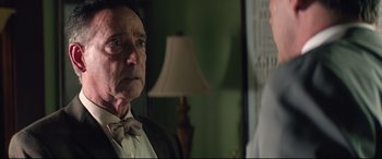 Movie still from “Richard Jewell” (2019), directed by Clint Eastwood – An older man wearing a bow tie looking at a younger man; Close Up shot, Over the shoulder angle
