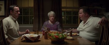 Movie still from “Richard Jewell” (2019), directed by Clint Eastwood – An older woman sitting at a table with a bowl of salad in front of her; Medium shot, Over the shoulder angle