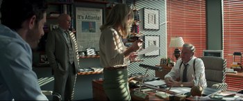 Movie still from “Richard Jewell” (2019), directed by Clint Eastwood – A woman standing in front of a desk holding papers; Medium shot, Over the shoulder angle