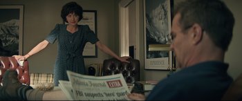 Movie still from “Richard Jewell” (2019), directed by Clint Eastwood – A woman standing in front of a man reading a newspaper; Medium shot, Over the shoulder angle