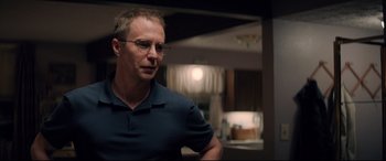 Movie still from “Richard Jewell” (2019), directed by Clint Eastwood – A man with glasses is standing in a room; Close Up shot, Over the shoulder angle