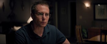 Movie still from “Richard Jewell” (2019), directed by Clint Eastwood – A person wearing glasses and a blue shirt; Close Up shot, Over the shoulder angle