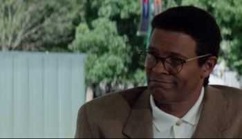 Movie still from “Richard Jewell” (2019), directed by Clint Eastwood – An older man wearing a brown suit and glasses; Close Up shot, Over the shoulder angle