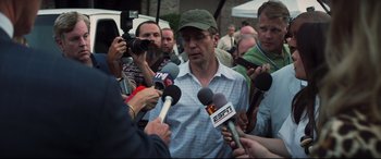 Movie still from “Richard Jewell” (2019), directed by Clint Eastwood – A group of people with microphones interviewing a man; Close Up shot, Over the shoulder angle
