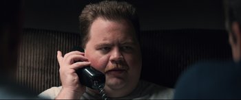 Movie still from “Richard Jewell” (2019), directed by Clint Eastwood – A person talking on a cell phone; Close Up shot, High angle