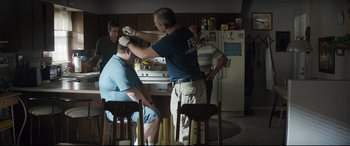 Movie still from “Richard Jewell” (2019), directed by Clint Eastwood – A group of men standing in a kitchen preparing food; Medium shot, Over the shoulder angle