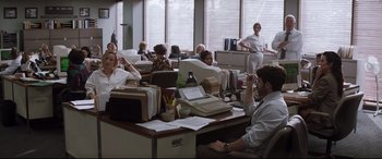 Movie still from “Richard Jewell” (2019), directed by Clint Eastwood – A group of people sitting around a desk; Wide shot, Over the shoulder angle