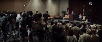 Movie still from “Richard Jewell” (2019), directed by Clint Eastwood – A group of people sitting in front of microphones; Extreme Wide shot, High angle