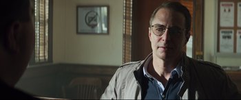 Movie still from “Richard Jewell” (2019), directed by Clint Eastwood – A person wearing glasses and a jacket; Close Up shot, Over the shoulder angle