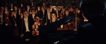 Movie still from “Rocketman” (2019), directed by Dexter Fletcher – A group of people in a room with musical instruments; Extreme Wide shot, High angle