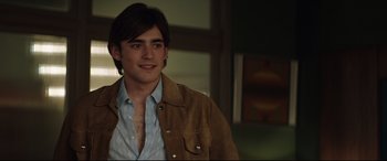 Movie still from “Rocketman” (2019), directed by Dexter Fletcher – A young man wearing a brown jacket and a blue shirt; Close Up shot, Over the shoulder angle