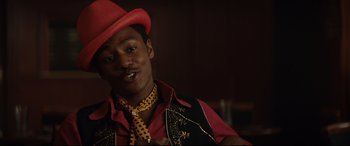 Movie still from “Rocketman” (2019), directed by Dexter Fletcher – A man wearing a red hat and a red tie; Close Up shot, Low angle