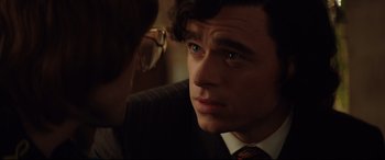 Movie still from “Rocketman” (2019), directed by Dexter Fletcher – A person wearing a suit and tie; Close Up shot, Over the shoulder angle