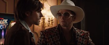 Movie still from “Rocketman” (2019), directed by Dexter Fletcher – A man in a white hat and a man in a white hat; Close Up shot, Over the shoulder angle