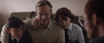 Movie still from “Rocketman” (2019), directed by Dexter Fletcher – An older man and a young boy pose for a picture; Close Up shot, Low angle