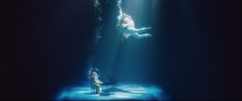 Movie still from “Rocketman” (2019), directed by Dexter Fletcher – An underwater scene with a person swimming in the water; Extreme Wide shot, High angle