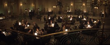Movie still from “Rocketman” (2019), directed by Dexter Fletcher – A group of people sitting at tables in a room; Wide shot, High angle