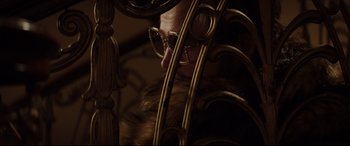 Movie still from “Rocketman” (2019), directed by Dexter Fletcher – A person wearing a pair of glasses on top of a metal fence; Close Up shot, Over the shoulder angle