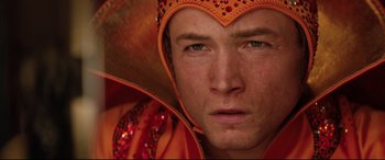 Movie still from “Rocketman” (2019), directed by Dexter Fletcher – A person wearing an orange outfit; Close Up shot, Low angle