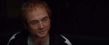 Movie still from “Rocketman” (2019), directed by Dexter Fletcher – A person wearing glasses and a jacket; Close Up shot, Over the shoulder angle