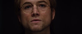 Movie still from “Rocketman” (2019), directed by Dexter Fletcher – A person wearing a pair of glasses; Close Up shot, Low angle