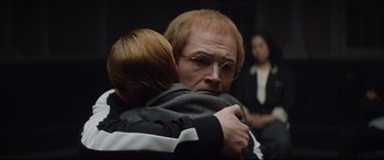 Movie still from “Rocketman” (2019), directed by Dexter Fletcher – An older man is hugging a young boy; Close Up shot, Over the shoulder angle
