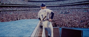 Movie still from “Rocketman” (2019), directed by Dexter Fletcher – A baseball player standing on top of a ramp; Wide shot, Over the shoulder angle