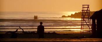 Movie still from “Romeo + Juliet” (1996), directed by Baz Luhrmann – A man standing on the beach looking out at the ocean; Extreme Wide shot, Over the shoulder angle