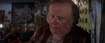 Movie still from “Romeo + Juliet” (1996), directed by Baz Luhrmann – An older man with a beard and mustache; Close Up shot, Low angle