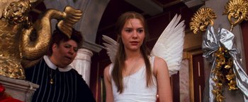 Movie still from “Romeo + Juliet” (1996), directed by Baz Luhrmann – A woman in a white dress with wings on; Medium shot, Low angle