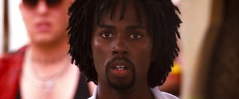 Movie still from “Romeo + Juliet” (1996), directed by Baz Luhrmann – A person with dreadlocks looking at the camera; Close Up shot, Low angle