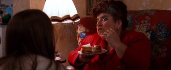 Movie still from “Romeo + Juliet” (1996), directed by Baz Luhrmann – A woman holding a piece of cake in her hand; Close Up shot, Over the shoulder angle